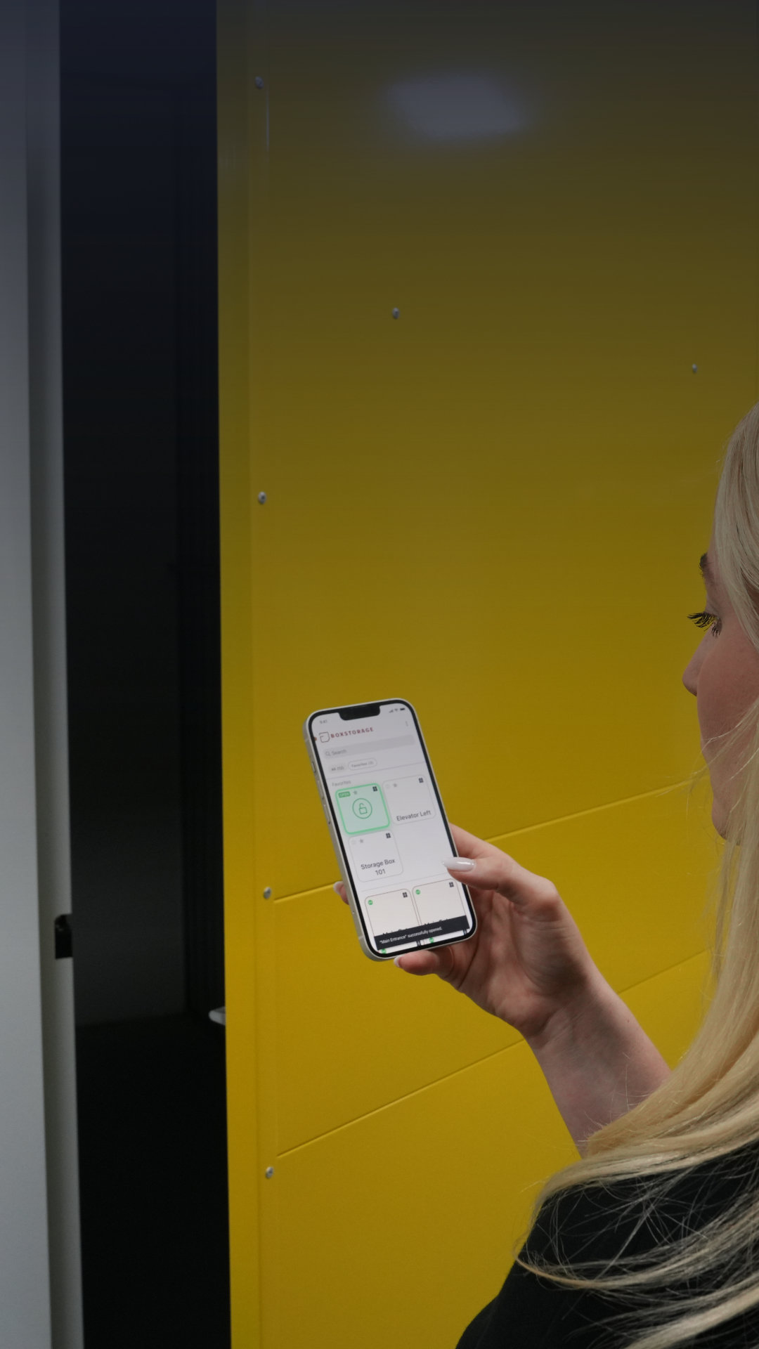 Person unlocking a storage unit with Sensorberg's One Access App on a smartphone