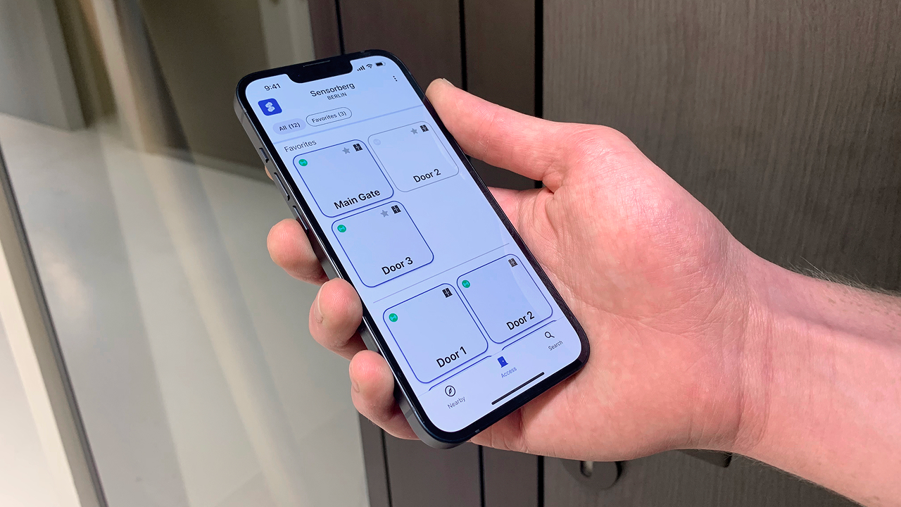 La aplicación Sensorberg One Access abierta en un smartphone, mostrando los controles de puerta en la entrada de la instalación